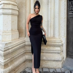 Detail of high-slit hem and horizontal ruching on a black one-shoulder maxi dress