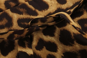 Makroaufnahme von Leopardenstoff mit Knotendetail und Textur eines Kleides mit V-Ausschnitt