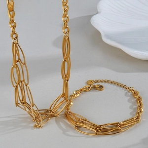 Close-up of golden multi-layer oval linked necklace and bracelet jewelry set in steel