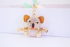 Macro shot of gold koala keychain with white opal belly and sparkling rhinestones