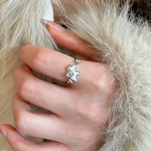 Macro shot of a silver butterfly ring with mother of pearl and zircon stones on hand