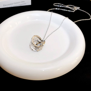 Detailed view of silver interlocking triple ring pendant with sparkling zircon accents