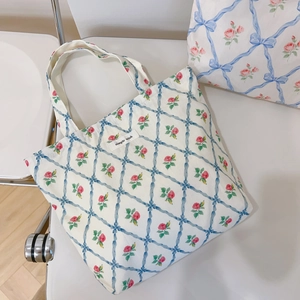 Detailed view of floral canvas tote bag with blue bow grid and pink flower patterns