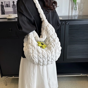 White quilted cloud tote bag with green floral pendant shown in lifestyle setting