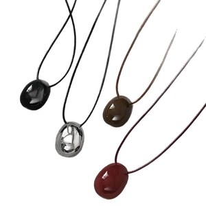Minimalist wax cord necklaces with smooth oval pebble pendants in four versatile colors