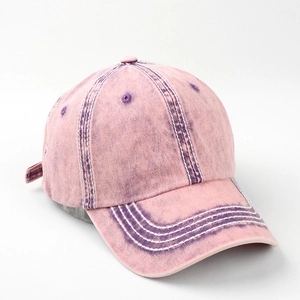 Detail of faded pink cotton baseball cap with four rows of white stitching on the brim