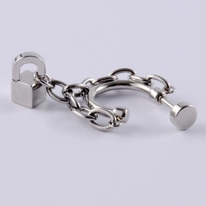 Detail of silver stainless steel stud earring with padlock pendant and chain ear cuff