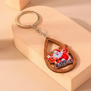 Détail du porte-clés en bois en forme de goutte avec Père Noël sur présentoir beige