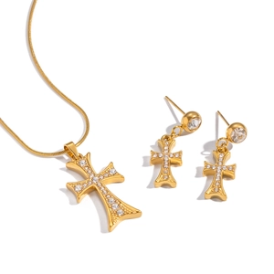 Parure collier et boucles d'oreilles croix dorée avec zircons sur fond blanc épuré