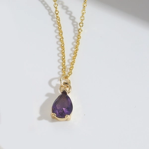 Detail of elegant purple teardrop pendant with gold chain and claw setting