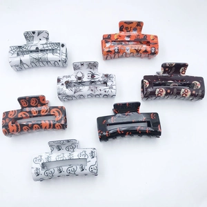 Set of 7 Halloween PVC hair claws with ghost, pumpkin and spider web designs on white background