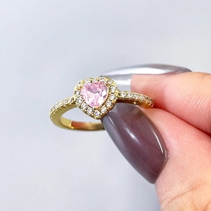 Macro shot of pink heart gemstone ring with gold band and pave-set cubic zirconia detail