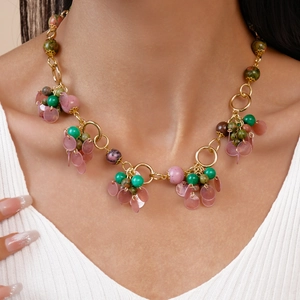 Detail of vintage geometric round stone pendant necklace on a gold metal chain