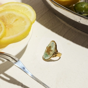 Detail of starfish ring with blue shell inlay and gold hammered metal for ocean style