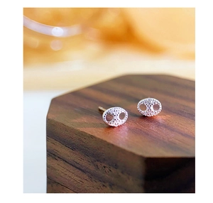 Macro shot of silver pig nose stud earrings with sparkling pavé zircons on wood