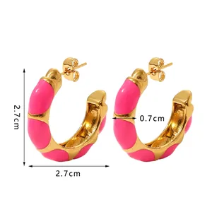 Detail view of pink enamel gold-plated C-shaped earrings with wave texture accents