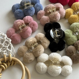 Detailed overhead view of plush ball hair claws in various vibrant colors for women