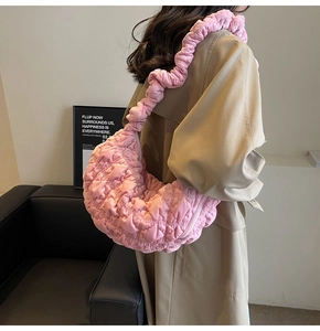 Detail view of pink pleated hobo bag showing spacious interior and ruched strap texture