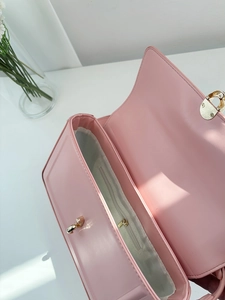 Top view of pink leather bag interior featuring a large main compartment and zipper pocket