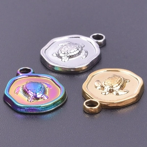 Dettaglio macro di ciondoli tartaruga in acciaio inossidabile in argento, oro e arcobaleno