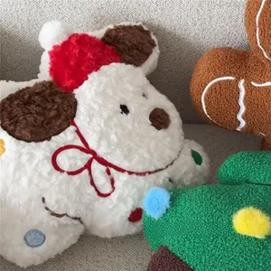Close-up of Christmas plush pillows including gingerbread man and tree on a gray sofa