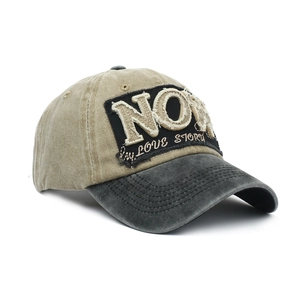 Detailed macro of vintage washed baseball cap featuring NOW patch and distressed embroidery