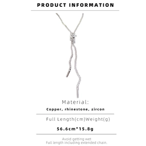 Macro detail of Y-shaped silver necklace with zircon zipper pendant and rhinestone chain