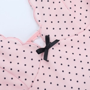 Detailed scalloped V-neck with polka dots and black ribbon bow on pink dress