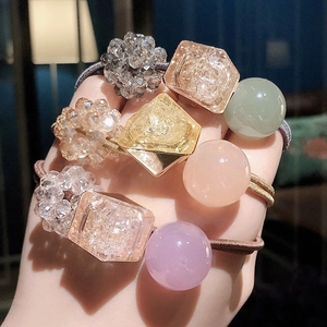 Close-up of four elastic hair ties with shimmering crystal beads and faceted gems for girls