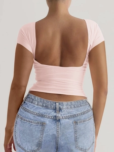 Gros plan d'un t-shirt rose moulant avec un décolleté en U sexy dans le dos pour femme