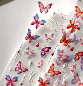 Macro shot of 5D embossed butterfly nail art stickers with delicate pearl chain details