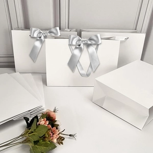 Premium white gift bags with silver ribbon handles and bow decoration in various sizes