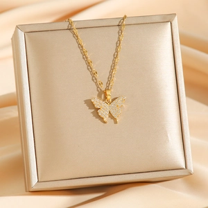 Collier pendentif papillon doré avec oxydes de zirconium sur fond de soie champagne