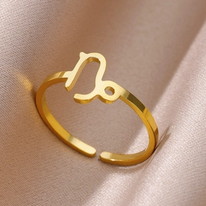 Macro view of polished 18K gold Capricorn zodiac sign on a minimalist open ring