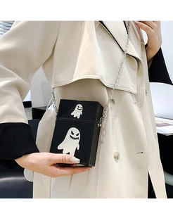 Detail of black crossbody bag with white ghost pattern and silver chain strap