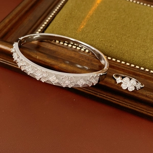 Macro detail of silver flower bracelet and ring set with cubic zirconia stones
