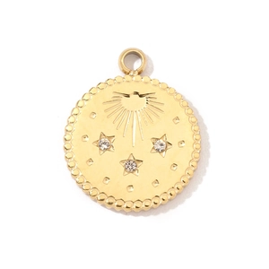 Dettaglio di un ciondolo vintage placcato oro con sole, stelle e strass scintillanti