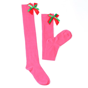 Detail of rose pink over-the-knee socks with festive red and green ribbon bows