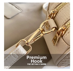Detail of high-quality light gold metal hook and zipper on a beige leather handbag