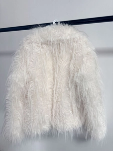 Close-up of fluffy white faux fur coat showing thick plush texture and warm material