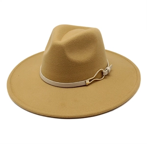 Close-up of wide-brimmed felt fedora with stylish gold buckle on thin decorative band