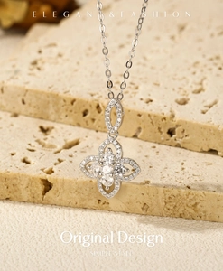 Detail of S925 sterling silver clover pendant with sparkling zircon on stone surface