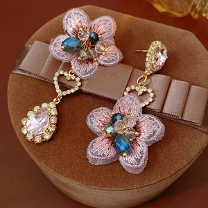 Detail of vintage asymmetric pink floral embroidery earrings with crystal heart drops