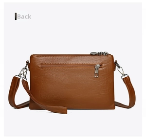 Back view of brown faux leather crossbody bag with zipper pocket and silver hardware