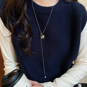 Detailed view of silver long sweater necklace featuring a horse pendant and pearl drop