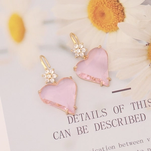 Close-up of pink heart earrings with gold edges and zircon flower details on hook