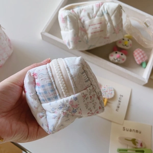 Vue détaillée d'une pochette en coton matelassé à fleurs avec fermeture éclair
