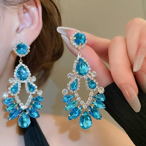 Detail of luxury teardrop fringe earrings with blue crystals and sparkling rhinestones