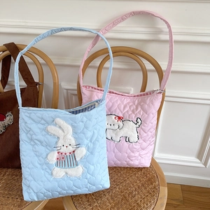 Quilted corduroy crossbody bags with cute rabbit and puppy embroidery on a wooden chair