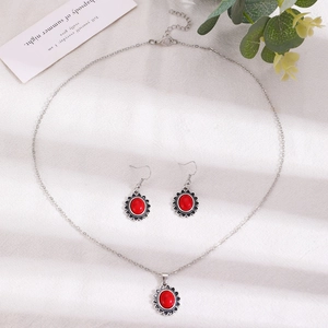Détails de la parure de bijoux bohème avec pierres rouges et bordures fleuries argentées